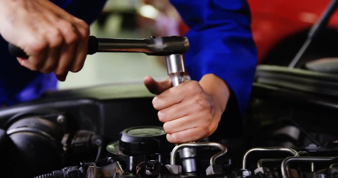 Hands of female mechanic servicing a car in garage 4k