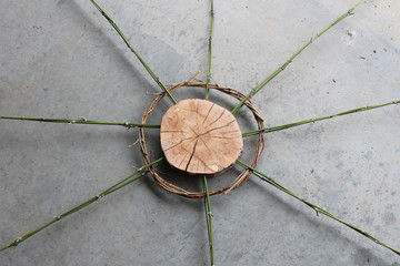 Wood, bamboo, and vines sculpture on a concrete surface, top view
