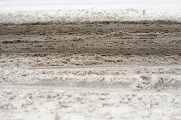 tire track and dirty snow in the street
