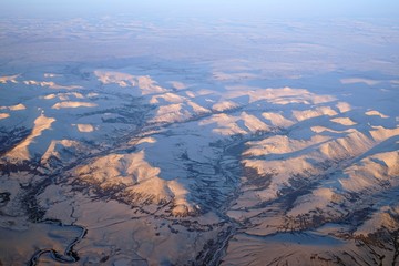 Aerial view of Alaskan mountains covered with snow at sunset north of Fairbanks