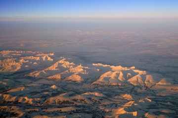 Aerial view of Alaskan mountains covered with snow at sunset north of Fairbanks