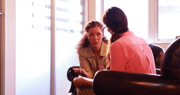 Female patient having discussion with therapist in clinic