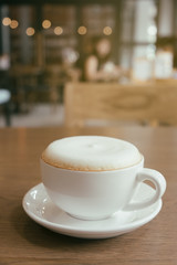 Cup of Cappuccino Coffee with foam froth cover on top. Cafe shop