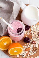 blackberry smoothies in a glass bottle on a tray top view