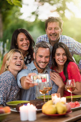 Friends taking a selfie on a terrace by a summer evening