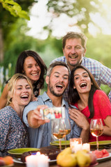 Friends taking a selfie on a terrace by a summer evening