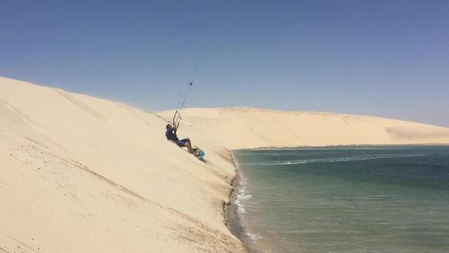 Man practicing kitesurfing on the white dune. Dakhla, Morocco.