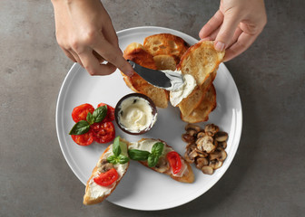 Woman cooking tasty bruschetta, top view