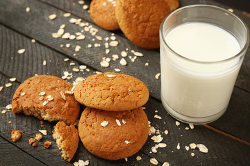 Oatmeal cookies with milk on wooden background