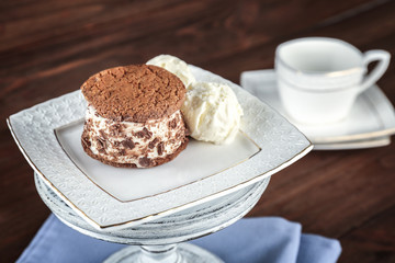 Ice cream cookie sandwich on stand on wooden background