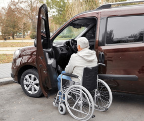 Naklejka premium Man in a wheelchair next to his car