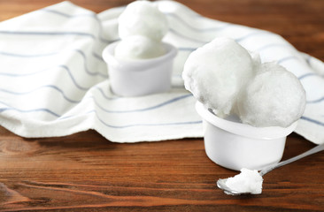 Fototapeta na wymiar Snowballs in ice cream cup on wooden table