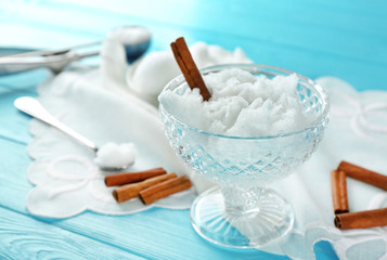 Melting snow in crystal bowl on blue wooden table