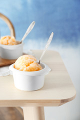 White cups with color ice dessert on wooden table