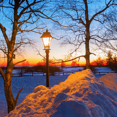 illuminated old street lamp in winter landscape
