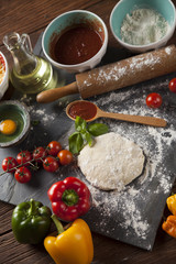 Preparing pizza with dough and tomato sauce
