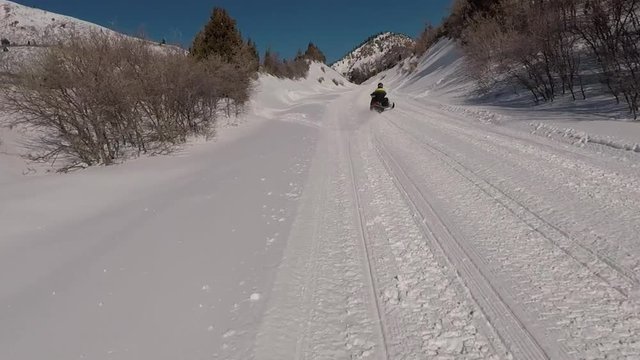 Snowmobile ride winter snow mountain high mark trail. POV, point of view. High mountain meadow and forest at high speed high in central Utah in winter. Recreation and fun.
