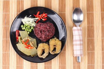 Brown jasmine rice topped green chicken curry and fish.
