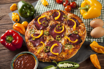 Tasty pizza, tomatoes and others ingredients on a wooden backgro