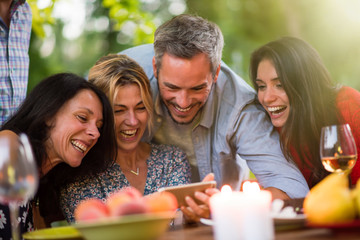 Group of friends having fun by watching photos on a smartphone