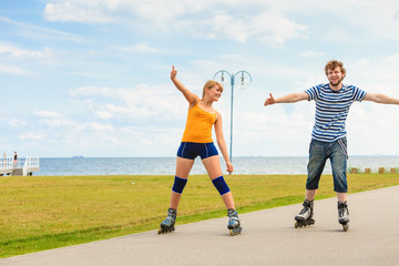 Young couple on roller skates riding outdoors