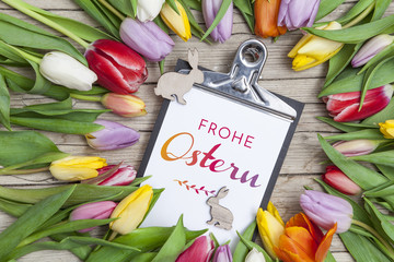 Frische bunte Tulpen vor einem Holzhintergrund mit Osterhasen