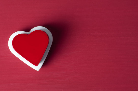 Red heart on white heart on red grunge background.