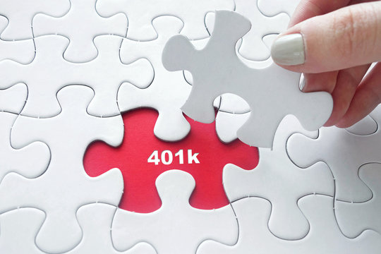 Hand placing  jigsaw puzzle with 401k text