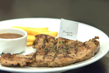 Grilled  pork steak, French fries and sauce