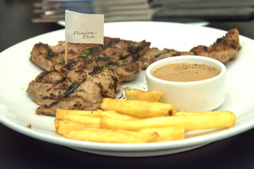 Grilled  pork steak, French fries and sauce