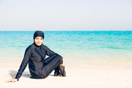Young Woman Wearing Burkini Sitting By The Beach