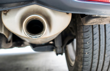 combustion fumes coming out of car exhaust pipe