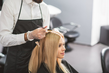 Fototapeta premium Young woman is sitting at hairdressers