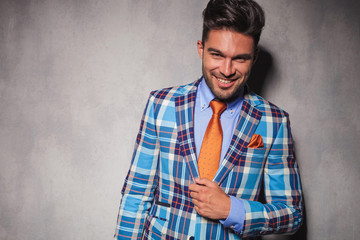 laughing young man in checkered suit and orange tie