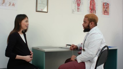 Happy young pregnant woman having a prenatal check up with her doctor