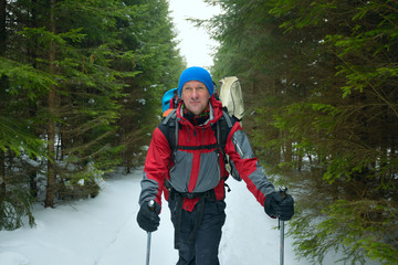 Happy man with backpack goes on a trail