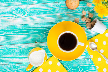 cup of black tea or coffee on yellow plate, yellow milk jug, cane sugar, cakes, dandelions,...