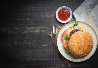 Fresh homemade burger cheeseburger on dark wooden background,