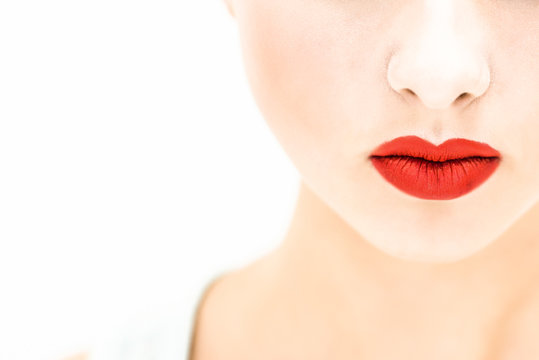 Close-up. Woman with red lips on a light background