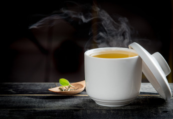 Cups of green tea on dark wooden background