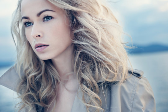 Beautiful young blond woman outdoors portrait near the lake