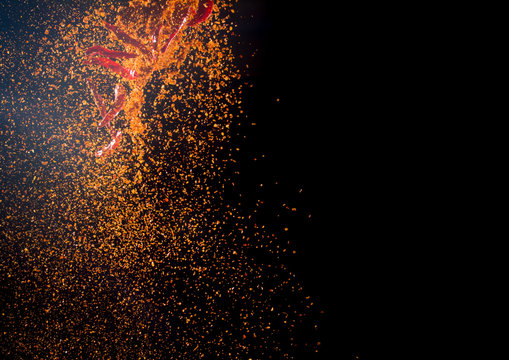 Cayenne pepper powder explosion isolated on black background