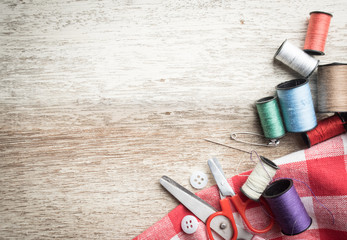 Sewing accessories,spools of thread with scissors on wood 