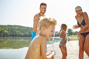 Familie hat Spaß und bespritzt sich mit Wasser