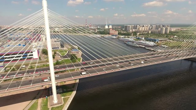 Flying to lanes of city ringroad (KAD) passing on cable-stayed Bolshoy Obukhovsky Bridge. Neva river, St. Petersburg, Russia
