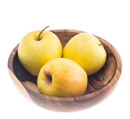 big ripe juicy yellow golden apples in wooden bowl isolated on white background