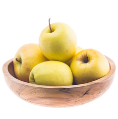 big ripe juicy yellow golden apples in wooden bowl isolated on white background