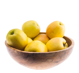 big ripe juicy yellow golden apples in wooden bowl isolated on white background