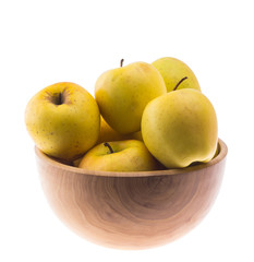 big ripe juicy yellow golden apples in wooden bowl isolated on white background