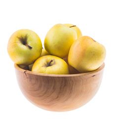 big ripe juicy yellow golden apples in wooden bowl isolated on white background